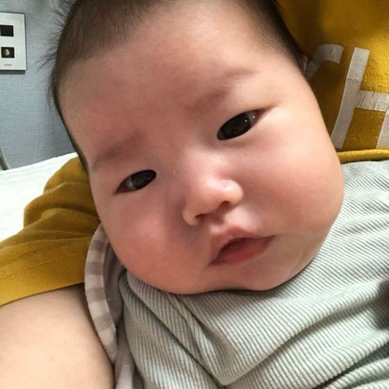 親の腕に抱かれて安心して休んでいる赤ちゃん