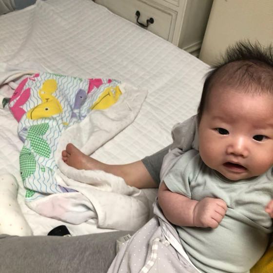 ベッドにもたれてカメラを見つめる、なんでもない一日の赤ちゃん。今日のひと言に添えたくなる、ふと撮ったその日の一枚