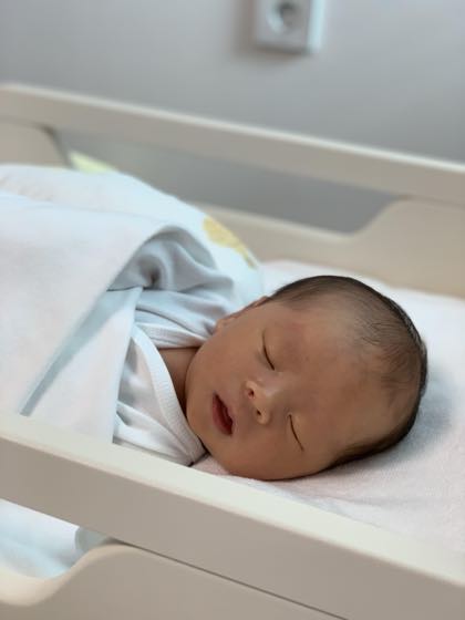 환절기 낮 햇살이 드는 방에서 아기 침대에 누워 옆으로 편안히 자는 아기