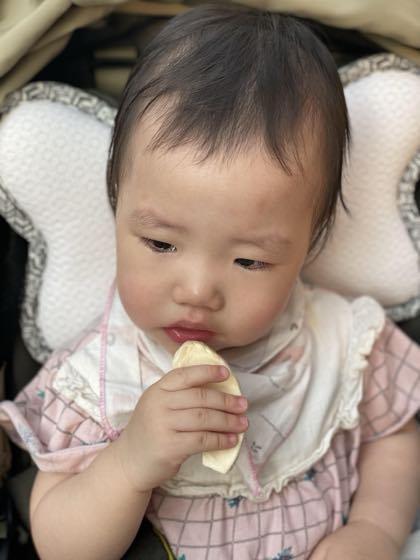 赤ちゃんせんべいを手に持って口に運ぶ赤ちゃんの姿