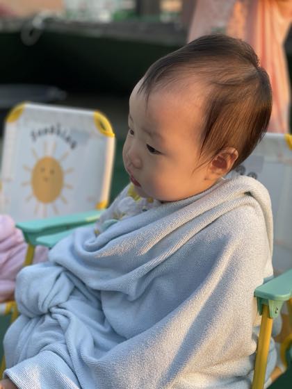 A baby wrapped in a towel and content after a bath