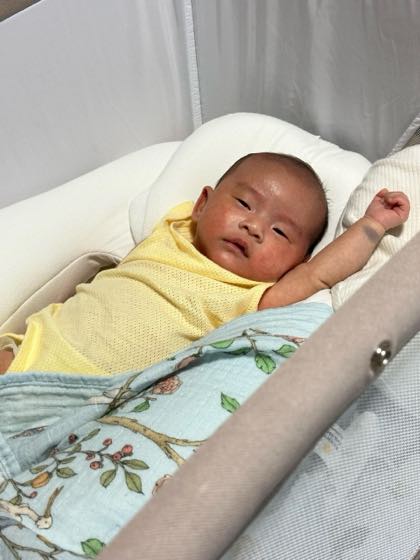 밝은 곳에서 아기 침대에 편안히 누워 있는 신생아
