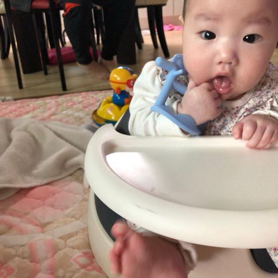 A baby biting on a blue teether
