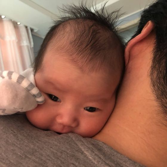授乳のあと赤ちゃんを肩に立てて抱き、げっぷをさせる親