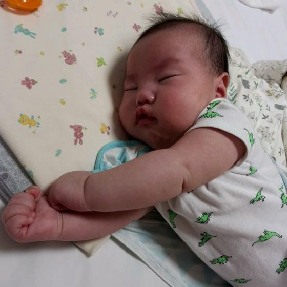 夏の夜、薄手の半袖を着て気持ちよさそうに眠る赤ちゃん