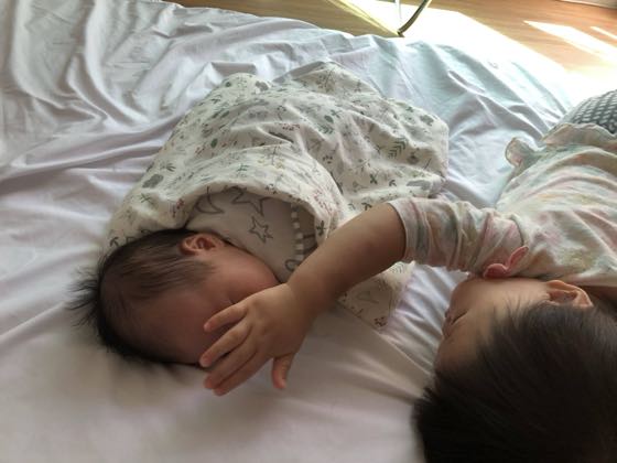 ベッドに並んで眠る二人の赤ちゃん